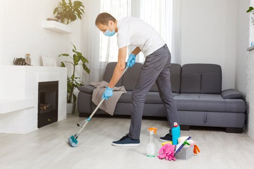professional cleaner mops floor wearing PPE
